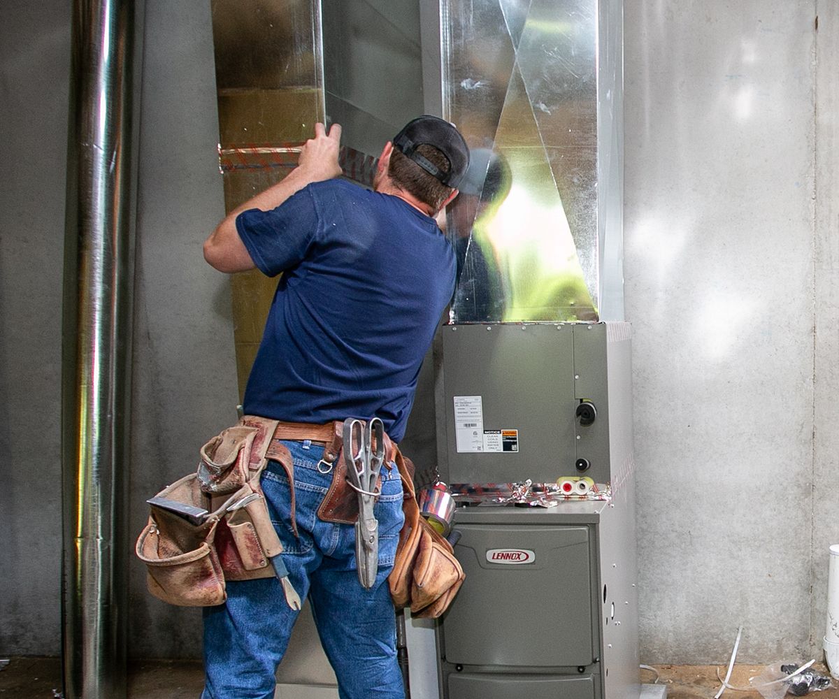 United Heating & Cooling technician servicing a furnace after receiving a call from a homeowner in the Kansas City Metro area