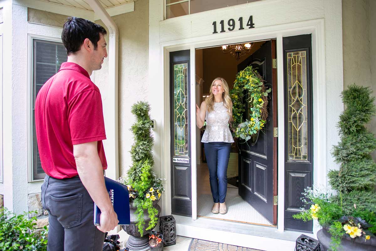 A customer meeting a United Heating and Cooling technician at their front door