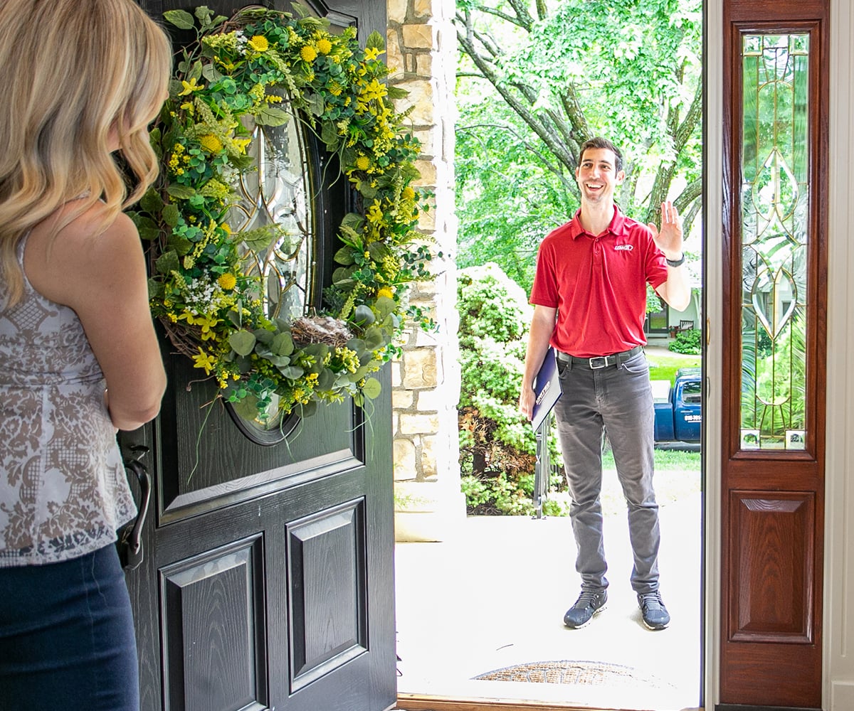 An air conditioning repair technician from United Heating and Cooling greeting a customer outside their door An air conditioning repair technician from United Heating and Cooling greeting a customer outside their door