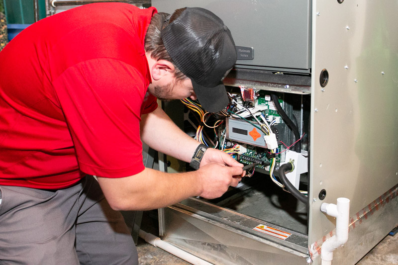 A technician performing AC maintenance to a home's air conditioning system. A technician performing AC maintenance to a home's air conditioning system.